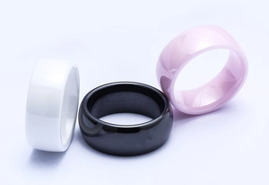 Close-up of 8mm polished ceramic rings in white, black and pink with glossy finish