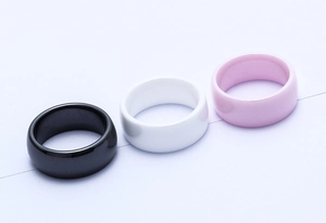 Three 8mm wide ceramic rings in black, white, and pink with polished mirror finishes