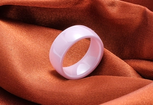 Detailed view of an 8mm wide polished pink ceramic ring with a smooth domed surface