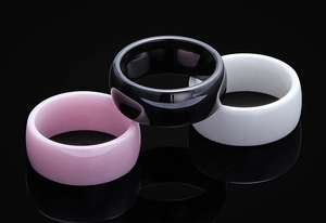 Close-up of polished black white and pink ceramic rings with smooth mirror finish