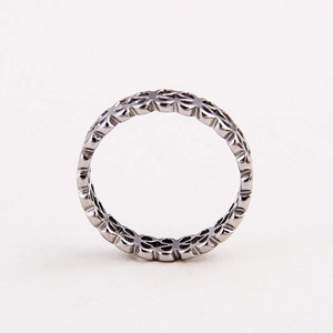 Close-up of a silver ring featuring a continuous geometric hollow pattern design