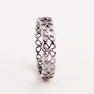 Macro shot of silver ring featuring a hollow four-leaf clover pattern and geometric cutout