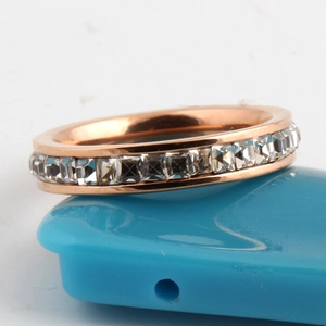 Close-up of rose gold eternity ring featuring a row of square-cut cubic zirconia stones