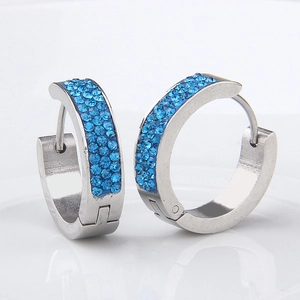 Macro view of silver stainless steel hoop earrings with three rows of blue crystals