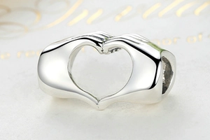 Vista macro dettagliata del charm in argento sterling S925 a forma di gesto del cuore