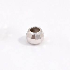Macro shot of faceted S925 sterling silver bead showing laser-cut geometry and center hole