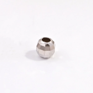 Macro detail of a faceted S925 sterling silver bead with a laser cut reflective surface