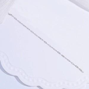 Detailed close-up of a silver S925 sterling silver paperclip chain on a white tray