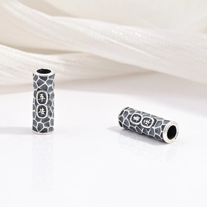 Dettaglio macro di perline in argento S925 con incisione Ping An e texture lavica