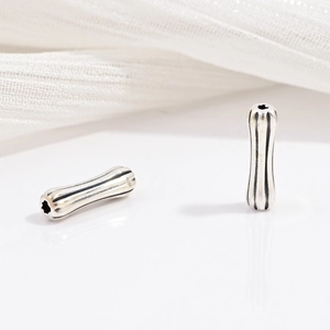 Dettaglio di perline cilindriche in argento sterling S925 con texture a strisce