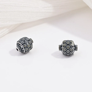 Vista macro dettagliata di perline in argento sterling S925 con motivi floreali e punzoni