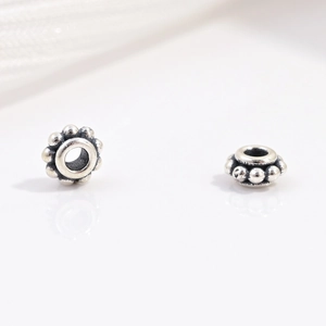 Macro shot of S925 sterling silver faceted beads with vintage oxidized floral texture