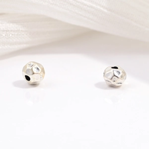 Macro shot of two vintage faceted silver beads for DIY jewelry with antique textures