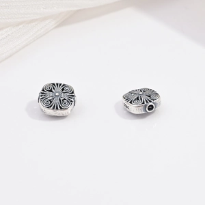 Vista macro di perle in argento S925 con motivi floreali e finitura in stile vintage