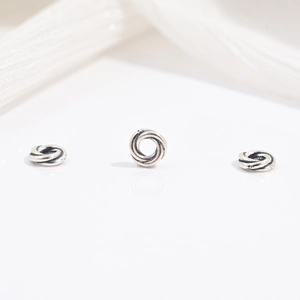 Close-up of three vintage S925 sterling silver gear beads with twisted rope texture
