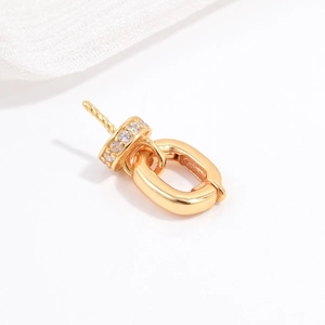 Macro detail of S925 sterling silver gold pendant bail with sparkling cubic zirconia