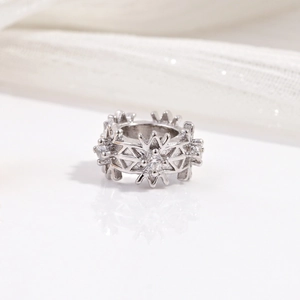 Macro shot of silver snowflake ring featuring clear cubic zirconia insets on white silk