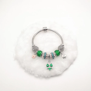 Detail van S925 zilveren armband met groene glaskralen en roze bikini-hanger sieraad