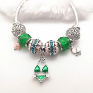Zilveren bedelarmband met hangers van een groene bikini, roze varkentje en witte vlinder
