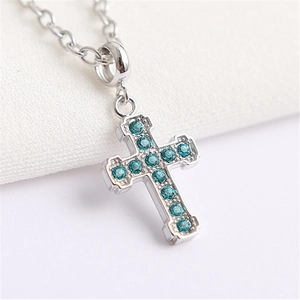 Macro detail of S925 sterling silver cross pendant with sparkling blue zircons