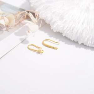 Detailed macro of gold plated S925 silver U-shape earring hooks with zircon and bead texture