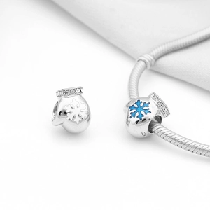 Macro view of S925 silver Christmas glove charms with snowflakes on a snake chain bracelet