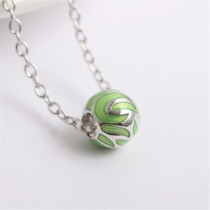 Dettaglio macro di perla in argento S925 con smalto verde e motivo a foglia