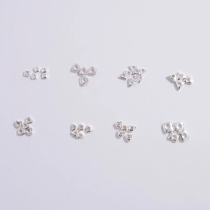 Macro detail of various S925 sterling silver beads in heart and geometric shapes for DIY