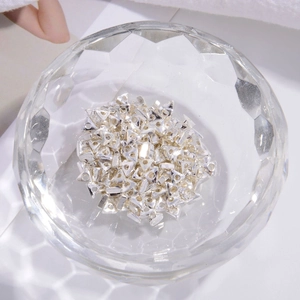 Close-up of triangle-shaped S925 sterling silver loose spacer beads in a crystal bowl