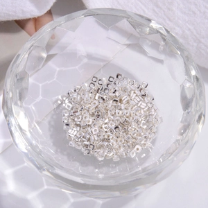 Macro shot of S925 sterling silver square spacer beads for DIY jewelry in a glass bowl
