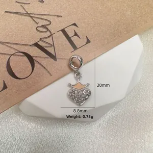 Macro shot of silver heart pendant with crown detail and zircon stones, 20mm height