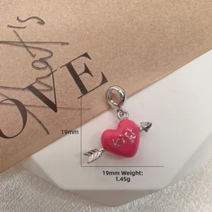 Macro shot of S925 silver pink enamel heart pendant with Kiss text, 19mm size