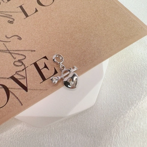 Detailed view of silver heart lock and key charm with sparkling crystal accents