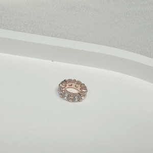 Detailed macro view of rose gold plated gear bead with pave set cubic zirconia stones