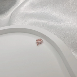 Close-up of rose gold silver spacer bead with cubic zirconia stones on silk background
