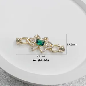 Dettaglio chiusura floreale oro 41mm con pietra smeraldo e accenti di diamante