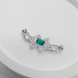 Macro scatto di una chiusura per collana a fiore d'argento con smeraldo e chiusura magnetica