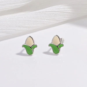 Vue macro des boucles d'oreilles maïs en argent sterling avec détails en émail vert