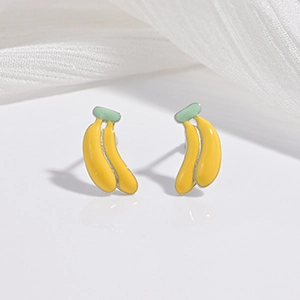 Détail macro de boucles d'oreilles banane en émail aux finitions jaune et vert vif