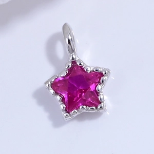 Dettaglio macro del ciondolo a stella rosso rosa con bordi perlati e gancio argento