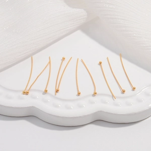 Dettaglio macro di 10 chiodini a testa sferica in argento S925 dorato per gioielli DIY