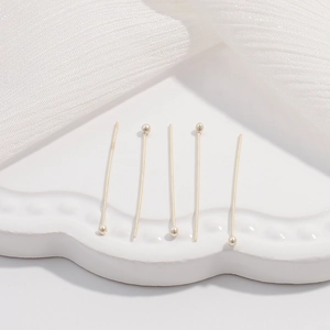 Dettaglio macro di cinque spilli a testa sferica in argento S925 per gioielli fai da te