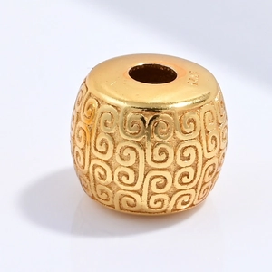Macro shot of S925 sterling silver cylinder bead with engraved patterns in gold finish