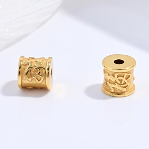 Macro detail of gold S925 silver cylinder beads with embossed Fuxi character for DIY