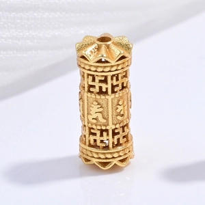 Detailed macro of a gold-plated S925 silver cylinder bead with Buddhist carvings