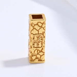 Close-up of golden S925 sterling silver barrel bead with textured finish and Chinese engraving