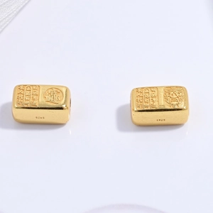 Détail macro de perles carrées en argent S925 avec visage de divinité et motifs traditionnels