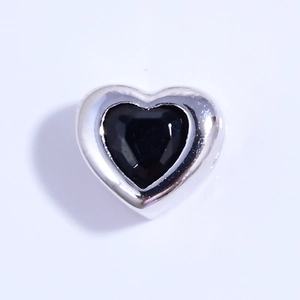 Vista detallada del dije corazón de plata S925 con gema negra facetada y pulida