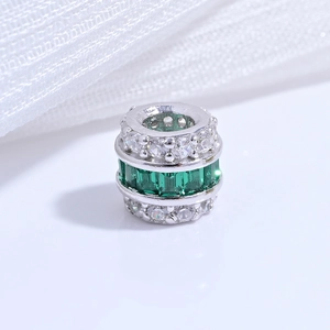 Macro detail of S925 sterling silver barrel bead with emerald and zircon pavé setting