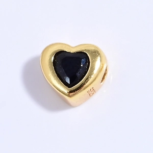 Vista macro del amuleto de corazón en plata S925 con circón negro y baño de oro